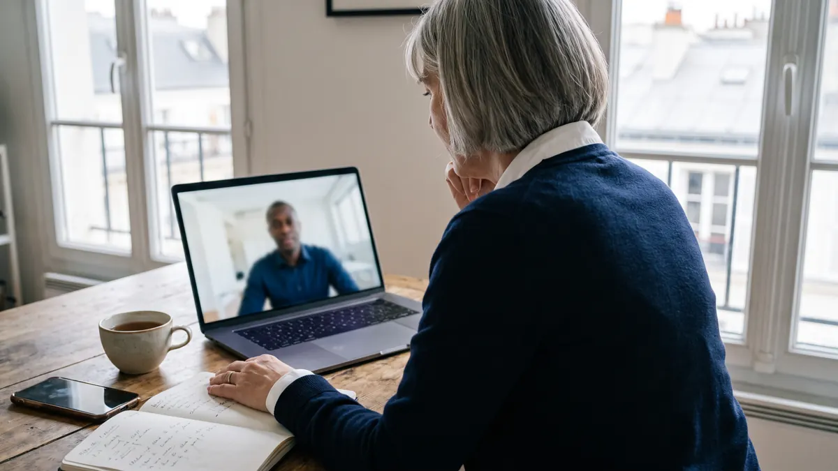 Une dirigeante française échange en visioconférence avec un entrepreneur ivoirien.